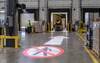 Projected forklift warning sign in warehouse loading area